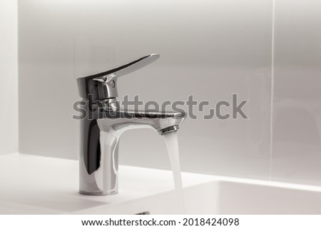 New Stainless faucet on clean wash basin sink in bathroom