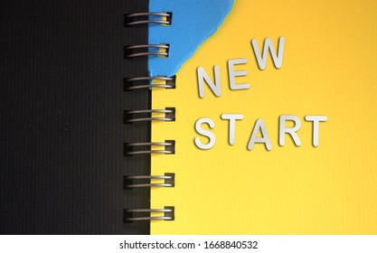 New Start - Words Made Of Silver Paper Letters Put On Open Copybook, Starting New Life New Chapter Concept.