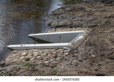 New Storm Water Drainage System That Drains Into A Stream With Stone And A Concrete Wall Placed Around It. 