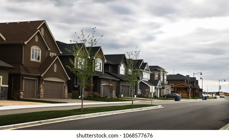 New Street In Residential Building District Suburb With Overcast Background.