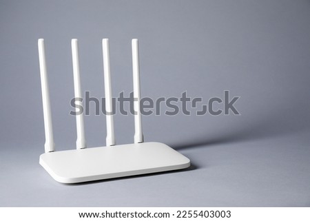 New stylish Wi-Fi router on grey background. Space for text