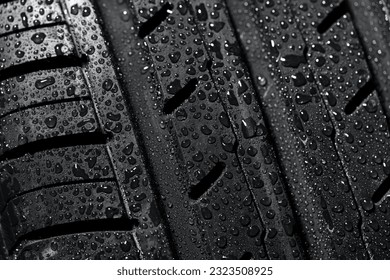 New summer tire protector in water drops close-up view. Driving in rainy weather concept.