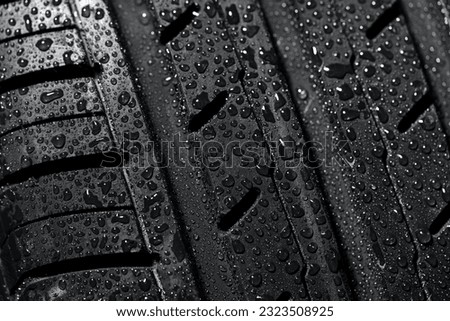 New summer tire protector in water drops close-up view. Driving in rainy weather concept.