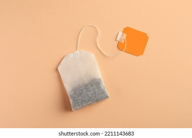 New Tea Bag With Tab On Pale Orange Background, Top View