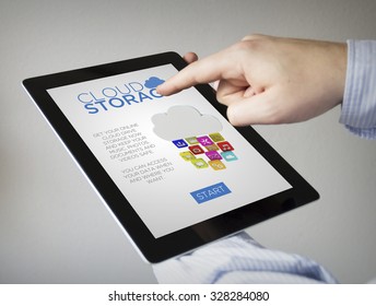 new technologies concept: hands with touchscreen tablet with cloud storage on the screen. Screen graphics are made up.