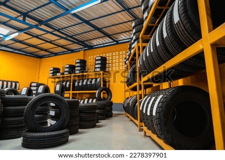 New tire is placed on the tire storage rack on large warehouse. Automobile industry, Car tires. 