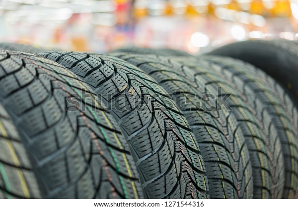 new tires for sale at booth\
in store. Winter Season Tire Tread. Brand New Car Tires on the\
Shelf.