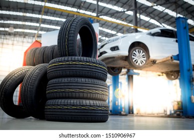 new tires that change tires in the auto repair service center, blurred background, the background is a new car in the stock blur for the industry, a four-wheeled tire set at a large warehouse