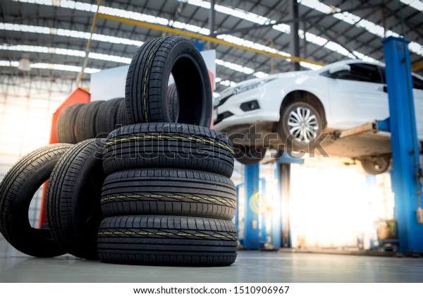 new tires that change tires in the auto repair\
service center, blurred background, the background is a new car in\
the stock blur for the industry, a four-wheeled tire set at a large\
warehouse