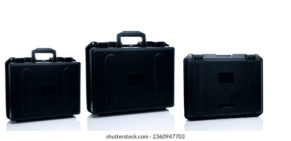 New toolbox or plastic case isolated on white background. Empty hard plastic suitcase with handle. Set of black plastic travel luggage. Modern case for toolkit, drone storage. Black new tool box.