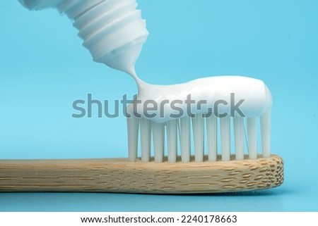 New toothbrush with toothpaste closeup on blue background closeup