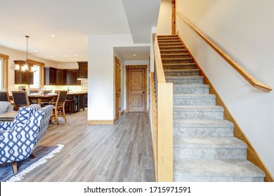 New townhome with white walls, wooden trim and living room interior with very long staircase.