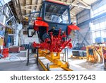 New tractor cabin or combine harvester on the assembly line of a tractor factory. Manufacturing of agricultural machinery at an industrial factory.