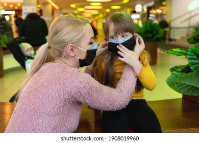 New Trend, Double Mask. A Woman In Two Masks, Dresses Her Nofocused Daughter A Second Mask