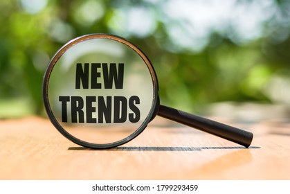 NEW TRENDS text written on magnifying glass. Main trend of changing something. Popular and relevant topics. New trends in business. Recent and latest trend. Evaluation methods. - Shutterstock ID 1799293459