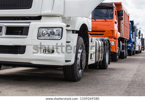 new\
trucks, dump trucks, semi-trailers in a row for\
sale.