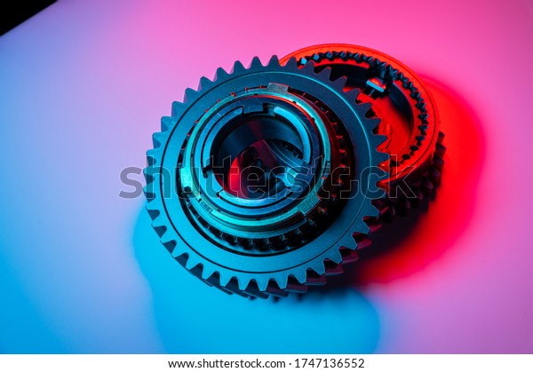 New two metal gears spare parts for gearbox\
in two colors red and blue. Conceptual image of the mechanical\
elements of the\
transmission