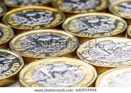 New UK One Pound Sterling Coins Laying Flat Closeup. British currency