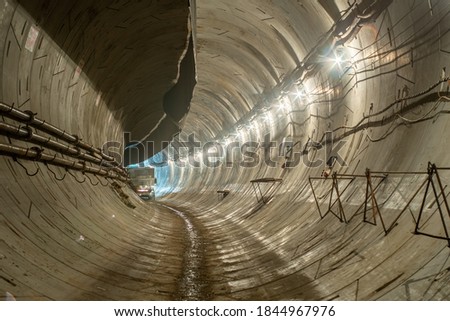 New, under construction, empty concrete round deep subway tunnel made of concrete blocks.
