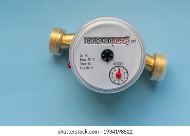 New water meter on a light blue background. Figures for measuring water in cubic meters. Round shape of the case. Impeller, red rotation arrow.