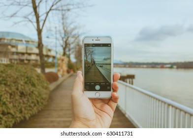 NEW WESTMINSTER, CANADA - JANUARY 26, 2017: Hand Holding IPhone With A Photo From The Landscape