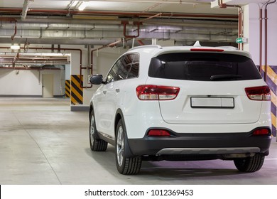 New white car at underground parking, rear view. - Shutterstock ID 1012369453