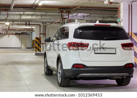 New white car at underground parking, rear view.