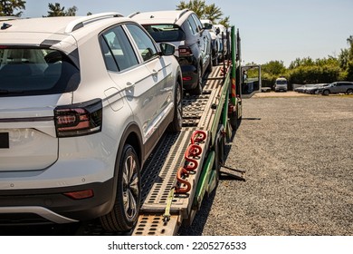 New White Crossover - SUV On Car Carrier Trailer, Car-carrying Trailer, Car Hauler, Auto Transport Trailer, Semi-trailer. Rear View Car. Rear View Trailer. Visible Taillamps.