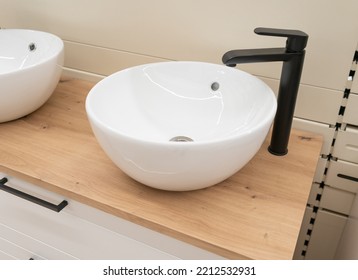 New white sink with black faucet. Contemporary wash basin, modern stylish washbasin, minimal round wash bowl, neat bathroom interior, white clean ceramic sink