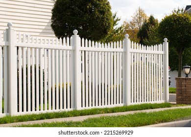 A new white vinyl fence by a grass area with trees behind it green property modern - Shutterstock ID 2215269929