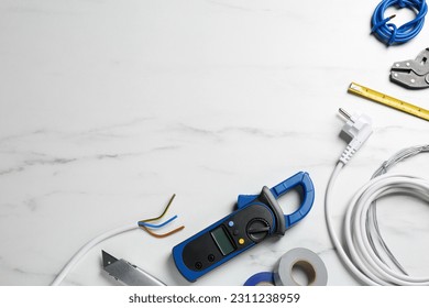 New wires and electrician's tools on white marble table, flat lay. Space for text - Shutterstock ID 2311238959