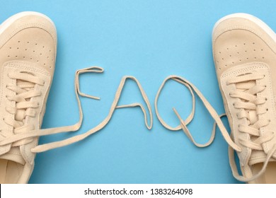 New women sneakers with laces in faq text. frequently asked questions concept. Flat lay on blue background.