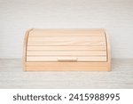 New wooden bread box on table top at home kitchen. Closeup. Front view.