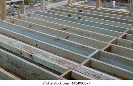 A new wooden, timber deck being constructed. it is on the decking. New deck patio
