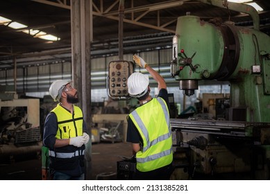 A New Worker, Latin Mix Race Man Worker Have Unkempt Beard In Safety Uniform Is Being Training On The Job Or Coaching From A Supervisor To Control The Heavy Machine In Industrial Manufacturer Factory.