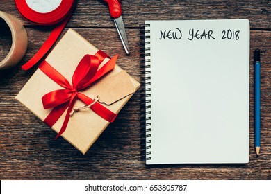 New Year 2018 On Blank Paper Note Book On Wood Table Background.