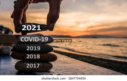 New Year 2021 Is Coming Concept. Covid Year 2020 To 2021 Background. Positive Turn Of Old Year. Happy New Year 2021 Replace Corona. New Hopes, Excitement With 2021. Man Adding Stone To Pebble Tower