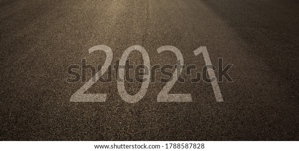 New Year 2021 Concept  Empty asphalt street\
road and writing text 2021 on\
roadway.