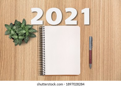 New Year 2021 Goals List. Office Desk Table With Notebooks And Pencil With A Pot Plant.