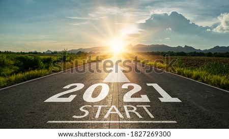 New year 2021 or start straight concept.word 2021 written on the road in the middle of asphalt road at sunset.Concept of planning and challenge or career path,business strategy,opportunity and change