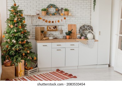 New Year 2022 American Kitchen Interior. Christmas Tree Decorated With Pieces Of Dried Oranges, Wreath Above The Table, Natural Colors, Organic Living. Selective Focus