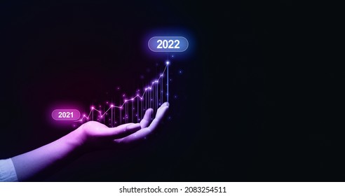 New year 2022  with great achievements. Businesswoman holding increase arrow graph corporate future growth year 2021 to 2022. Development to success and motivation.