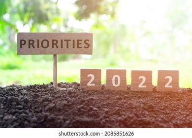 New Year 2022 Life Goals, Resolution And New Priorities Concept. Wooden Blocks Dice On A Natural Background At Morning Sunrise.