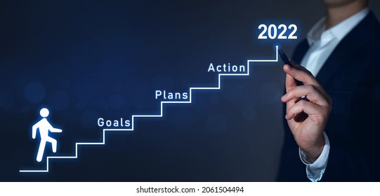 New Year 2022 Plan, Action And Goals. Businessman Pointing To The Growing Plan Of Successful Business In 2022 Year And A Figure Climbs The Ladder Of Success.