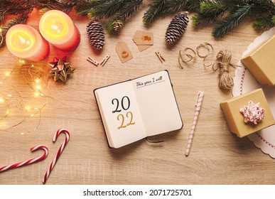 New year 2022 resolution notebook with blank paper to write goals and Christmas rustic decor stuff on a wooden background. Top view - Shutterstock ID 2071725701
