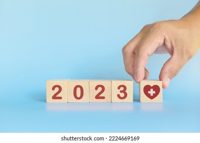 New year 2023 health goal and healthcare priority concept. Wooden blocks on blue background with icon. - Shutterstock ID 2224669169
