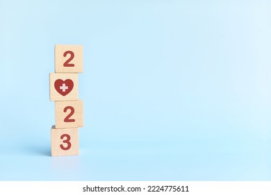 New Year 2023 Health Goal And Healthcare Priority Concept. Wooden Blocks On Blue Background With Icon.