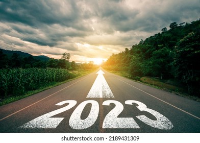 Nuevo año 2023 o concepto directo. Texto 2023 escrito en el camino en medio de la carretera asfaltada con al atardecer. Concepto de planificación, objetivo, desafío, resolución de año nuevo.
