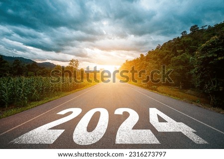 New year 2024 concept. Text 2024 written on the road in the middle of asphalt road with at sunset. Concept of planning, goal, challenge, new year resolution.
