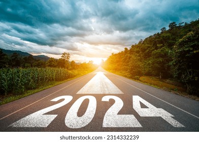 New year 2024 or straight forward concept. Text 2024 written on the road in the middle of asphalt road with at sunset. Concept of planning, goal, challenge, new year resolution.
